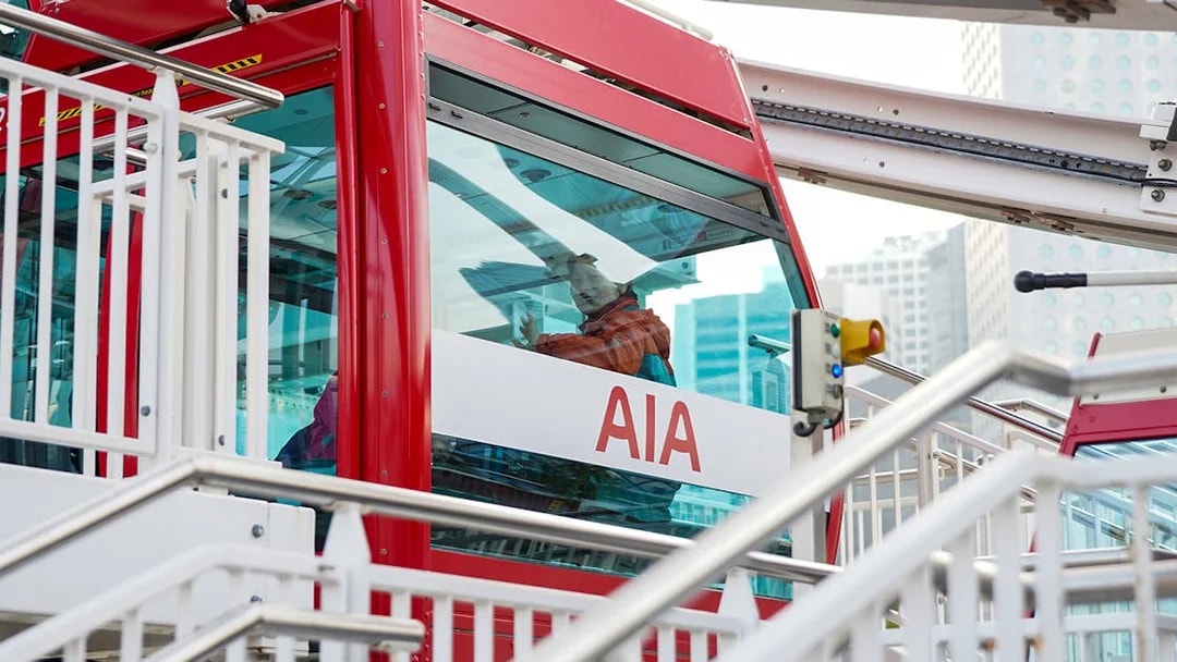 Hong Kong Observation Wheel cabin with passenger and cityscape background.