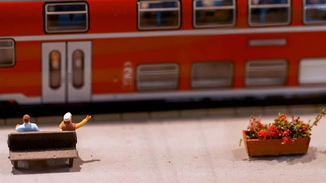 Miniature figures on a bench near a model train at Hzero Railway Enterprise.