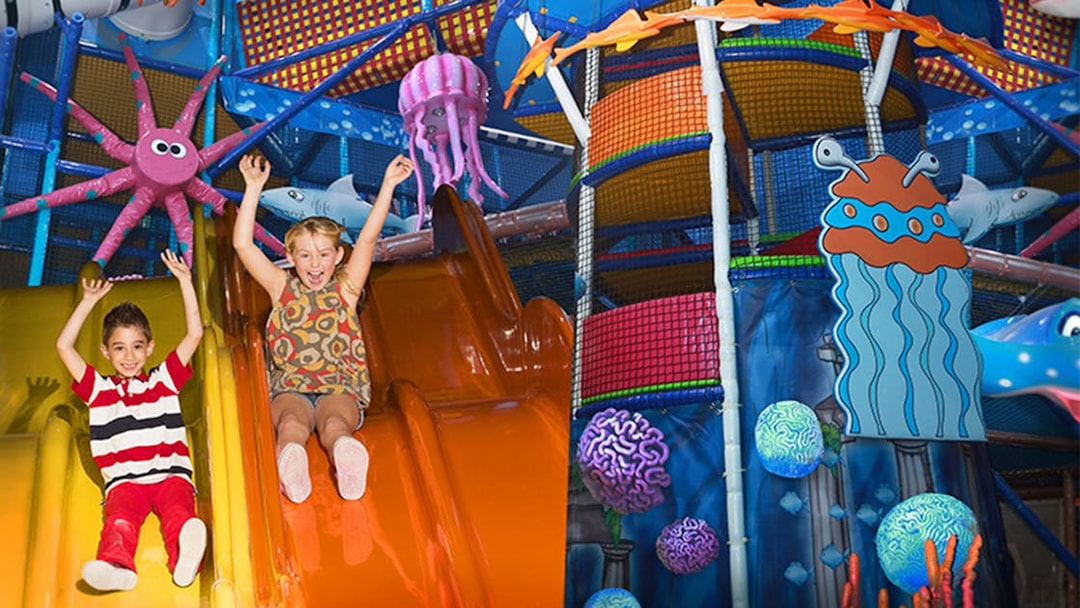 Children sliding in colorful play area at Katmandu Park.