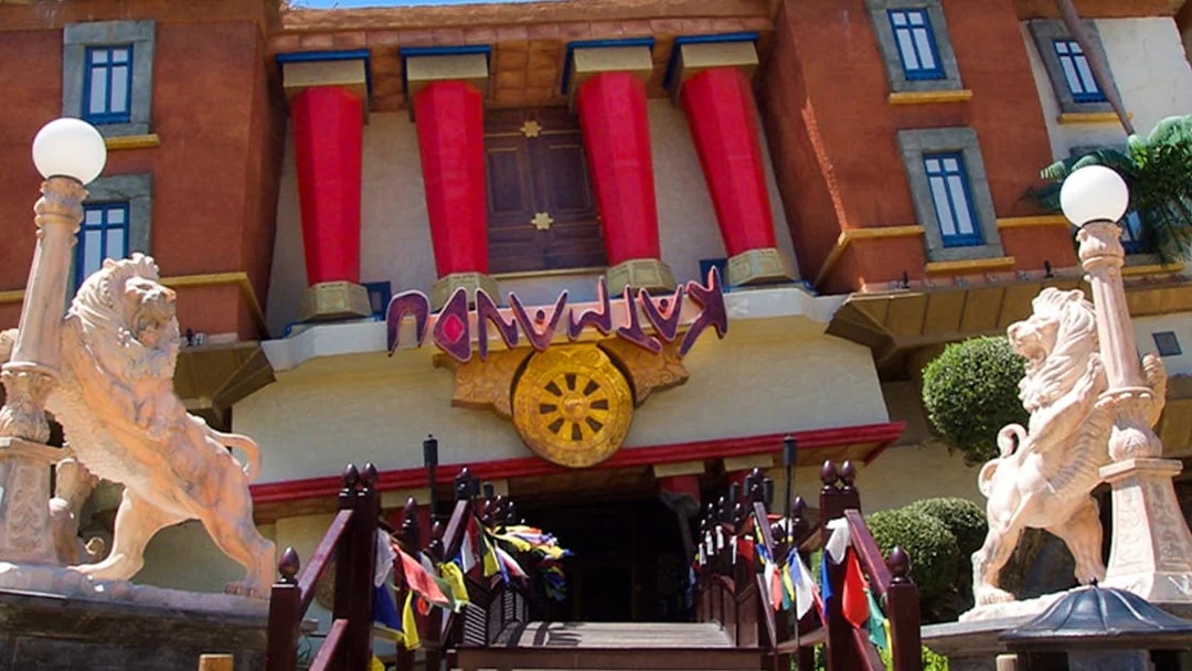 Katmandu Park entrance with lion statues and colorful flags, Mallorca.