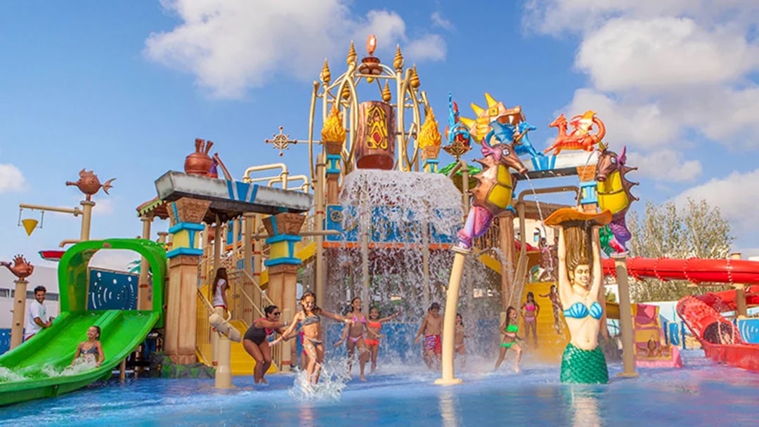 Children playing at the water park in Katmandu Park, featuring slides and colorful structures.