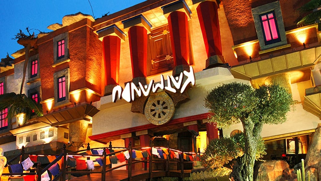 Katmandu Park entrance with vibrant lights and colorful flags in Mallorca.