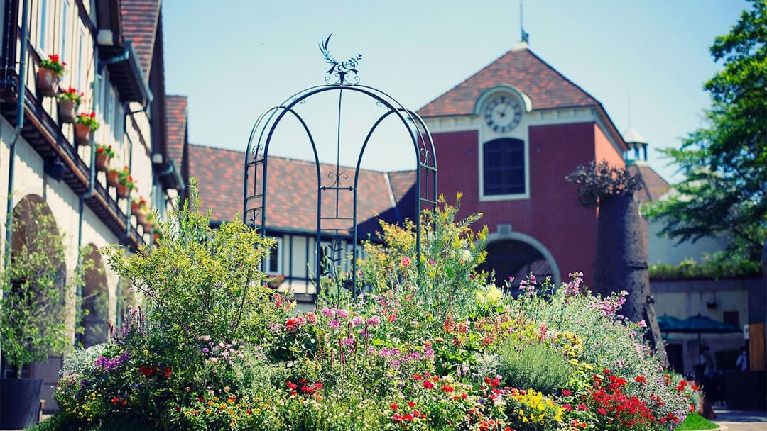 Kobe Nunobiki Herb Gardens with colorful flowers and a scenic building backdrop.