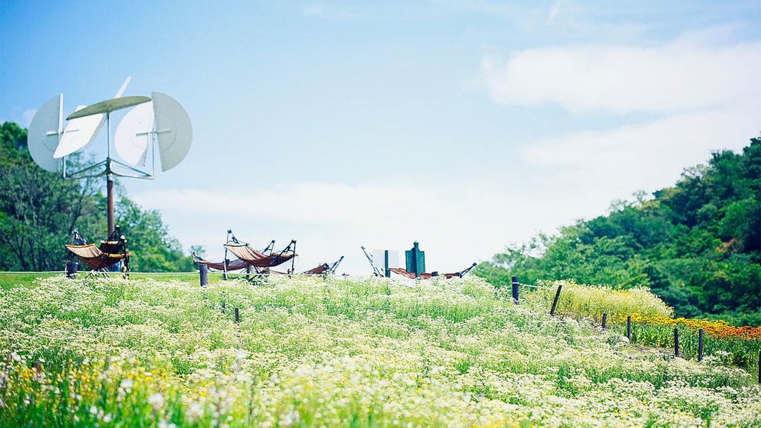 Kobe Nunobiki Herb Gardens with hammocks and windmill under clear sky.