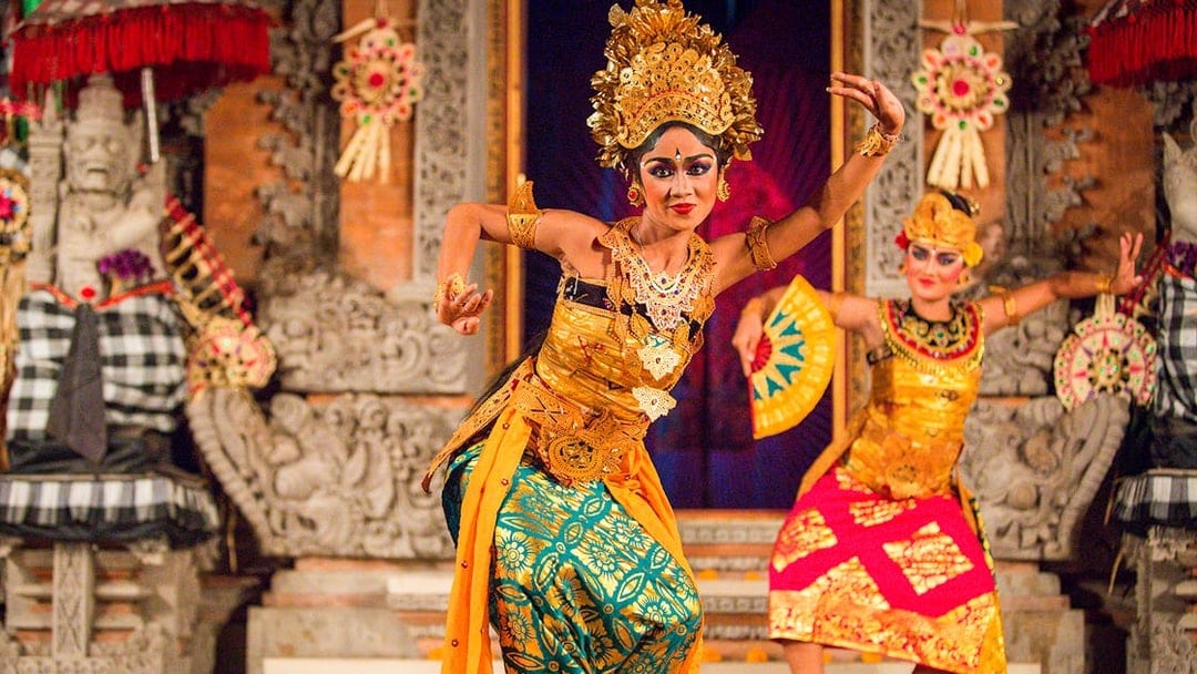 Legong dancers performing at Ubud Palace, Bali, in traditional costumes.