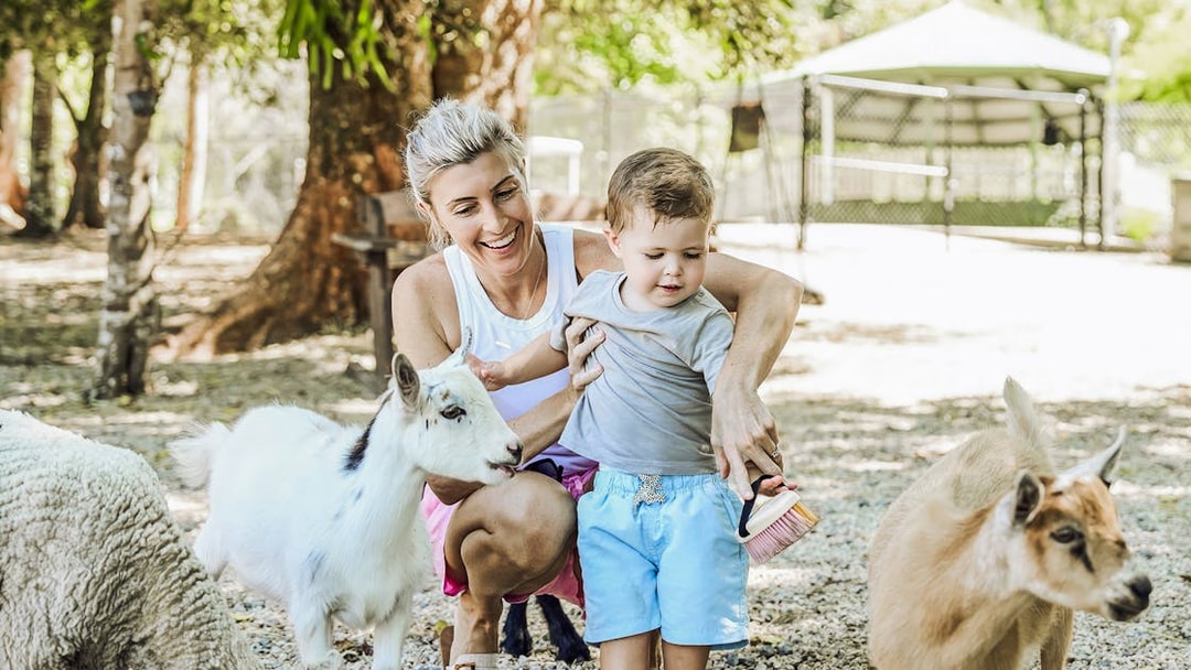 Mother and child petting goats at Maleny Botanic Gardens and Bird World.