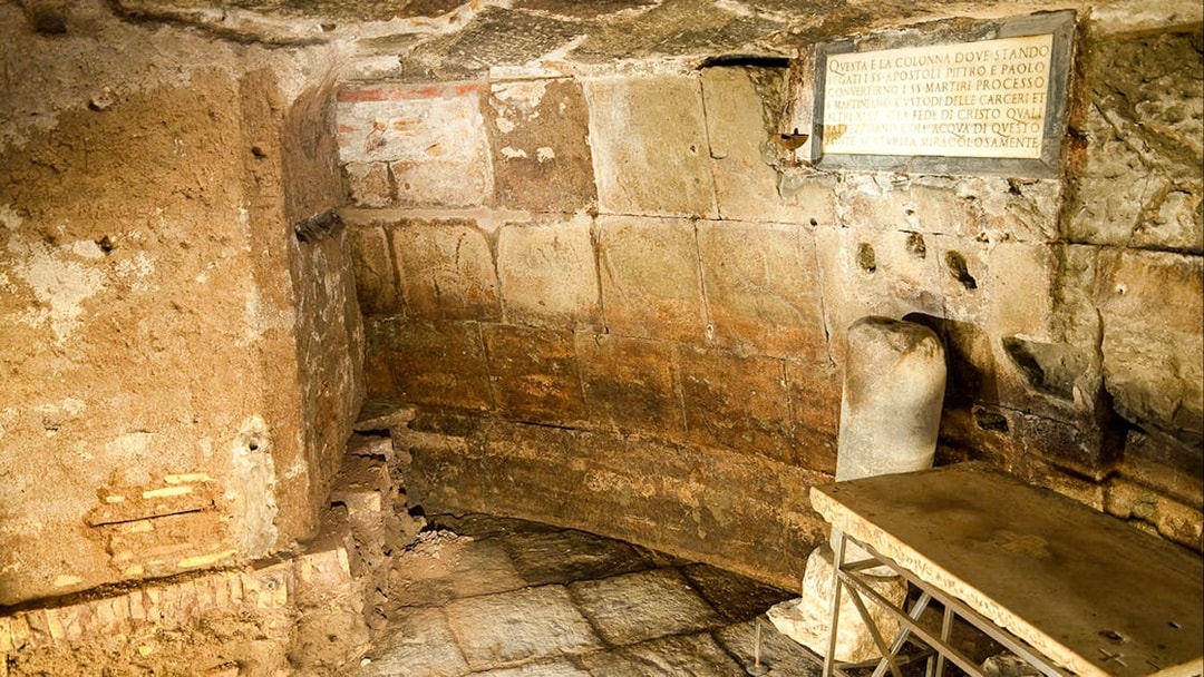 Mamertine Prison interior with ancient stone walls and inscription in Rome.