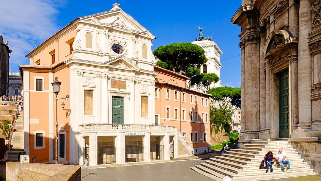 Mamertine Prison entrance with nearby historical buildings in Rome, Italy.