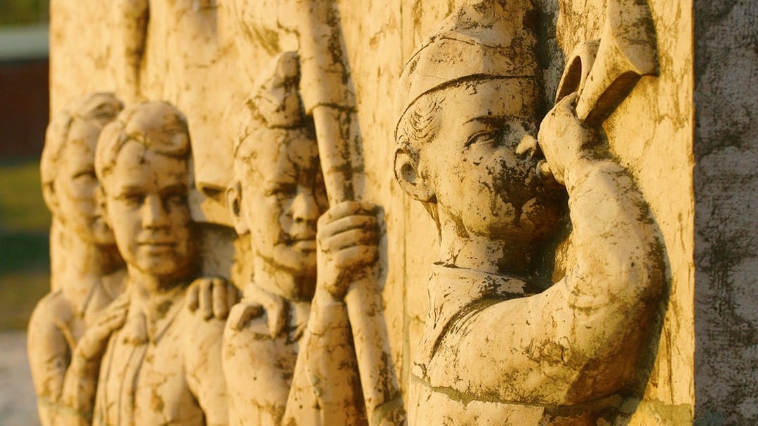 Stone relief of soldiers with a bugler at Memento Park, Budapest.