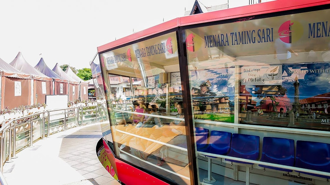 Menara Taming Sari cabin with tourists seated, Melaka.