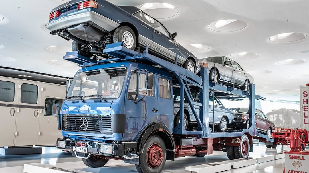 Car transporter exhibit at Mercedes Benz Museum, Stuttgart, showcasing vintage vehicles.