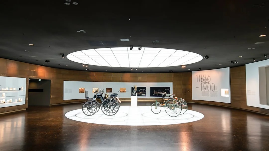 Historic vehicles displayed inside Mercedes Benz Museum.