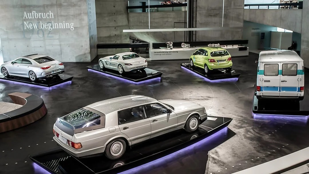 Mercedes Benz Museum exhibit featuring classic and modern cars on display platforms.