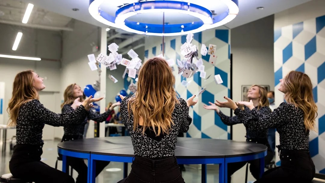 Visitors experiencing optical illusion with mirrors and cards at Museum of Illusions Kuala Lumpur.