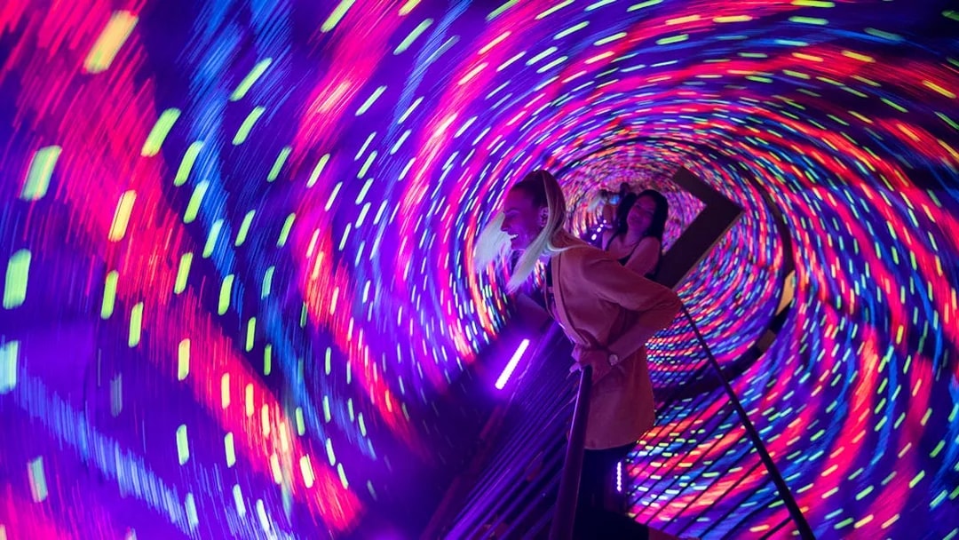 Visitors in a colorful vortex tunnel at Museum of Illusions Kuala Lumpur.