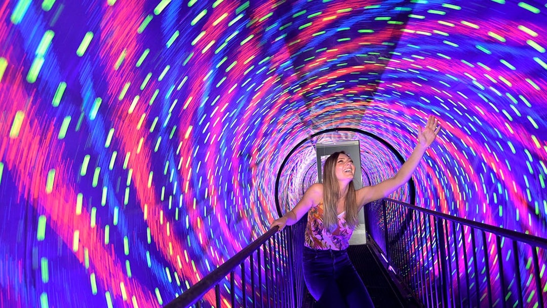 Visitor enjoying colorful vortex tunnel at Museum of Illusions Kuala Lumpur.