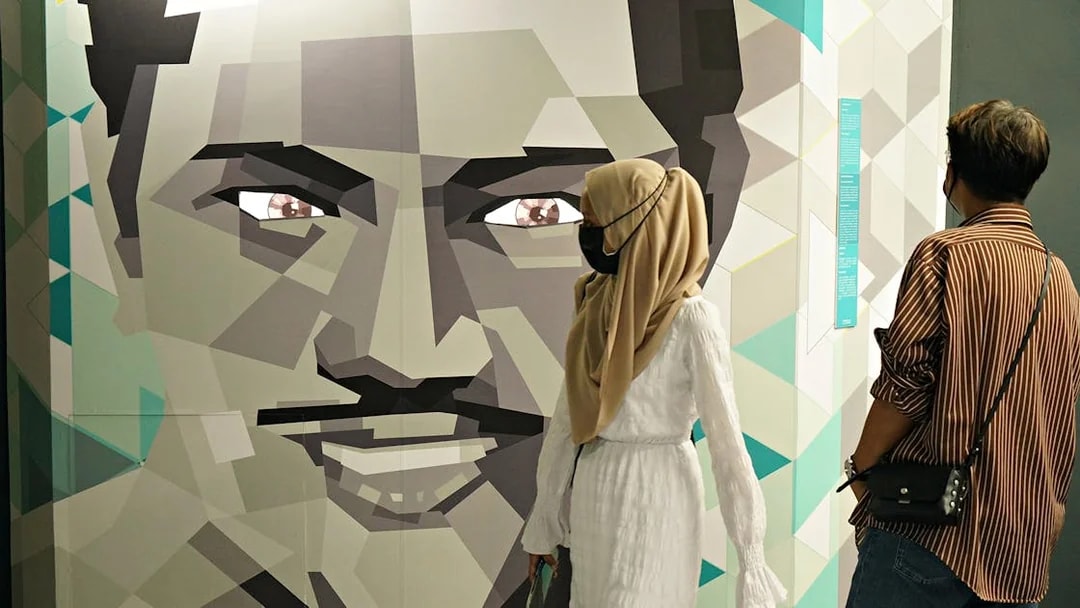 Visitors observing geometric face art at Museum of Illusions Kuala Lumpur.