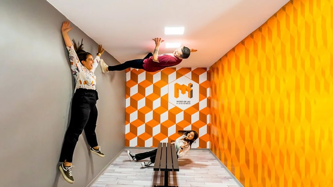 Visitors experiencing anti-gravity room at Museum of Illusions Seville.