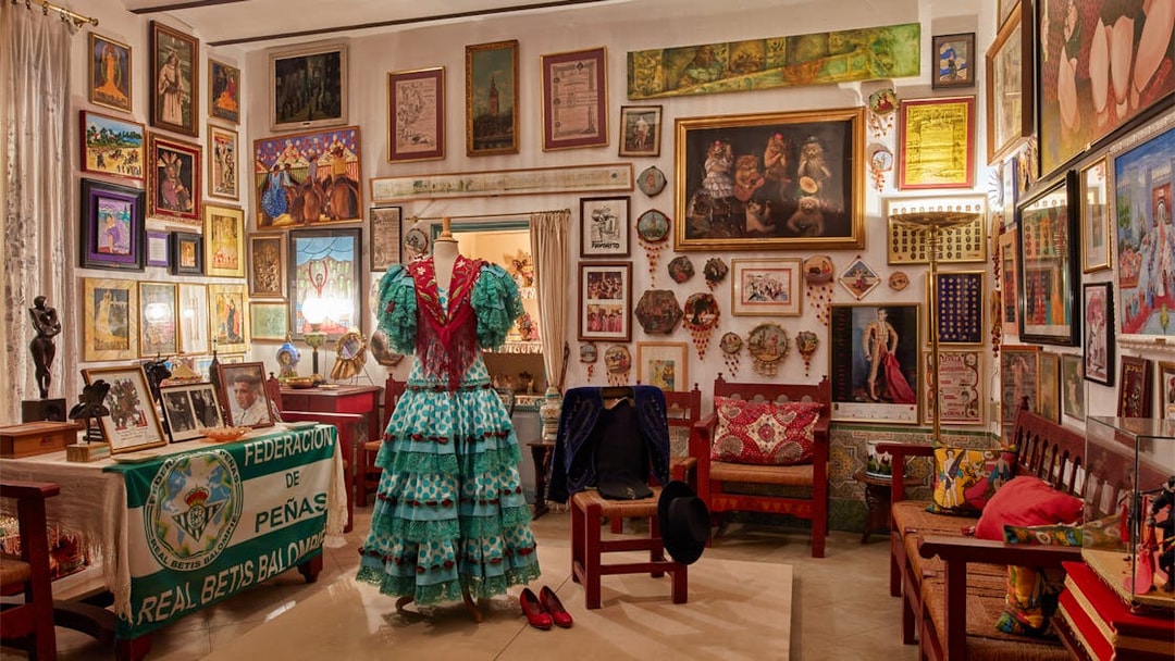 Flamenco dress display in art-filled room at Palacio de las Dueñas, Seville.