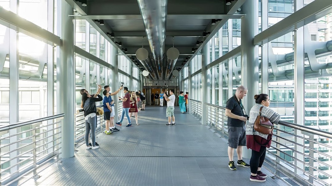 Visitors on the SkyBridge at Petronas Twin Towers, Kuala Lumpur, taking photos and enjoying views.