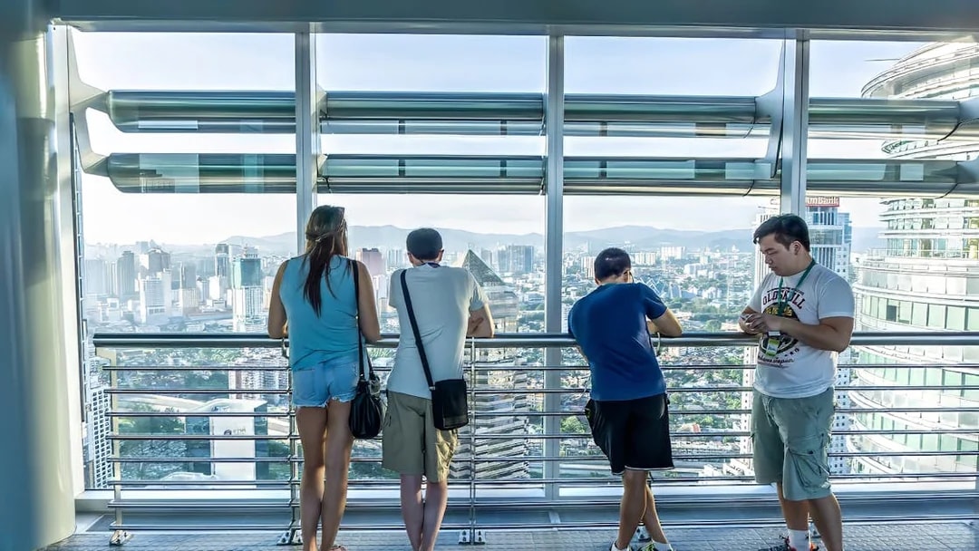Visitors enjoying the view from Petronas Twin Towers skybridge in Kuala Lumpur.