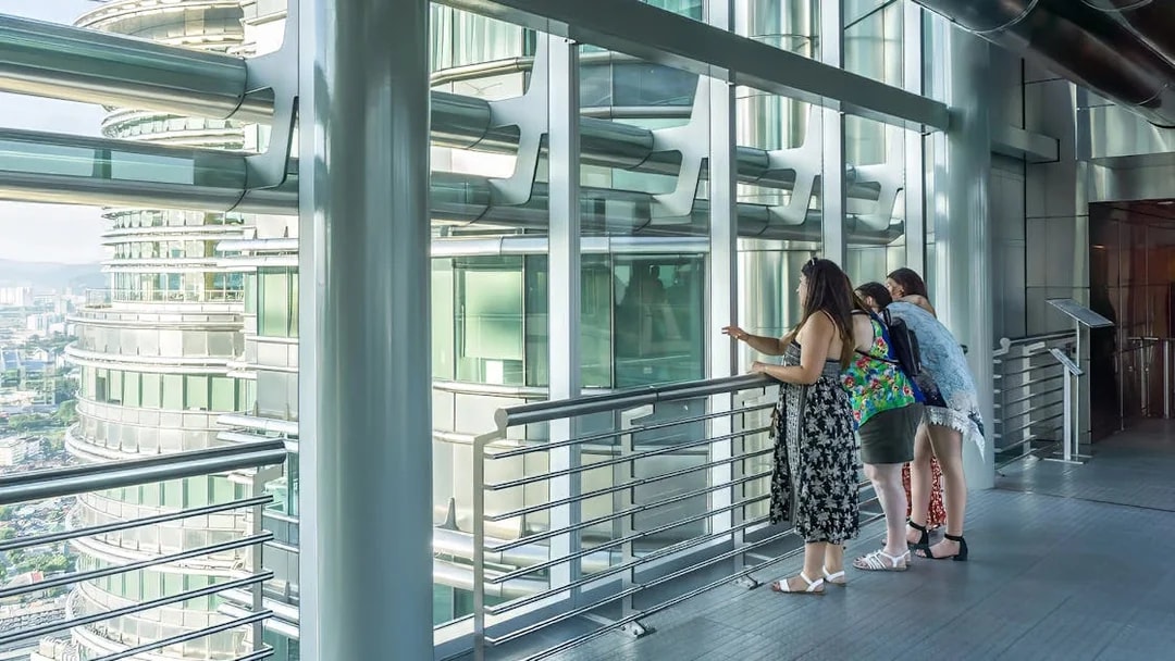 Visitors observing the Petronas Twin Towers from the sky bridge in Kuala Lumpur.