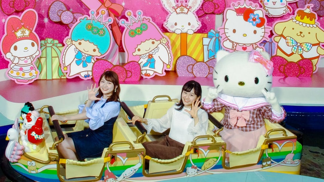 Visitors enjoying a ride with Hello Kitty at Sanrio Puroland, Japan.