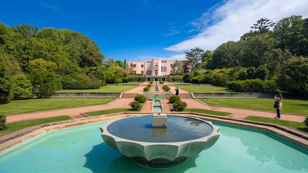 Serralves Museum garden with fountain and pink Art Deco building in Porto, Portugal.