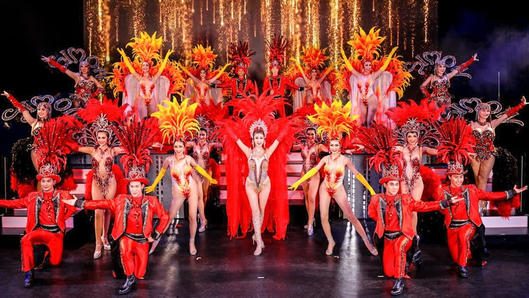 Performers in vibrant costumes on stage at Simon Cabaret Show, Phuket.