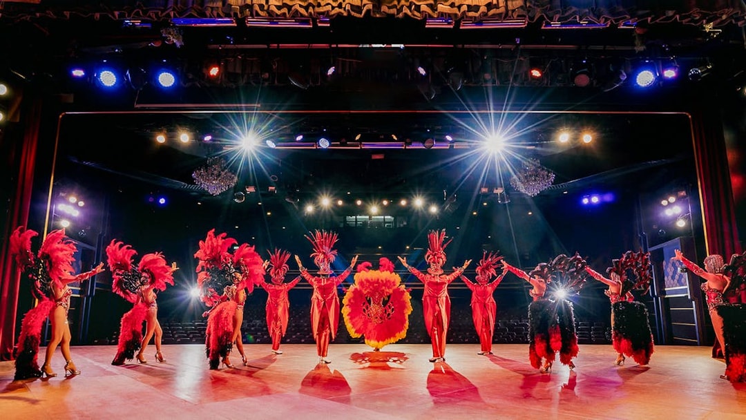Performers in vibrant costumes on stage at Simon Cabaret Show, Phuket.