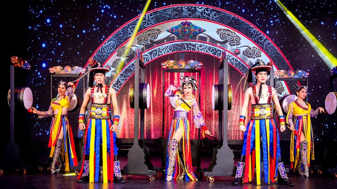Performers in colorful costumes on stage at Simon Cabaret Show, Phuket.