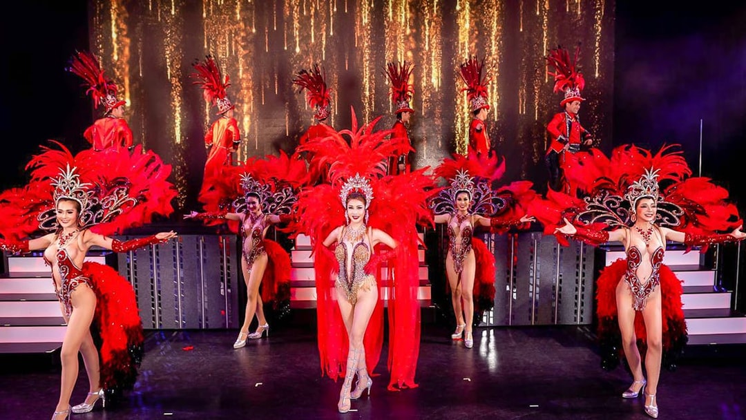 Performers in vibrant costumes on stage at Simon Cabaret Show, Phuket.