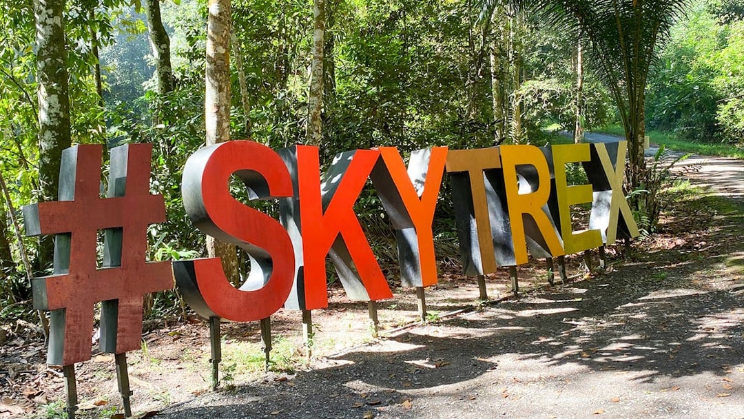Skytrex Adventure Langkawi sign in lush forest setting.