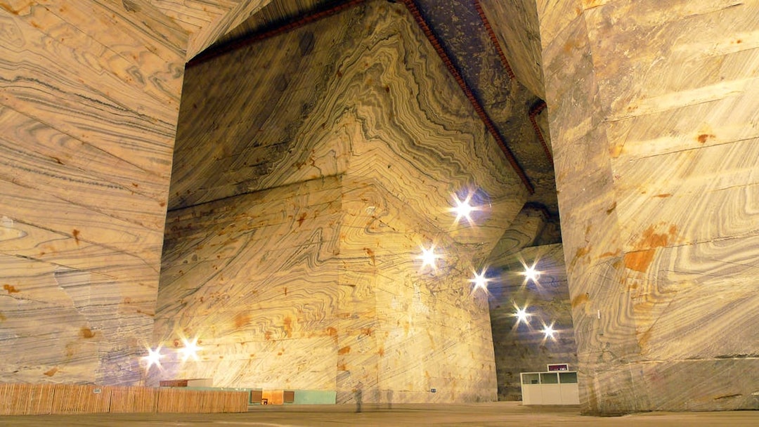 Slanic Salt Mine's vast underground chamber with illuminated salt walls in Bucharest.