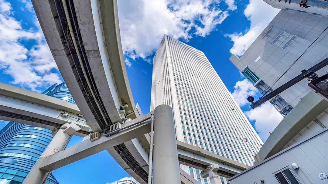 Sunshine 60 building in Ikebukuro with elevated highways and blue sky.