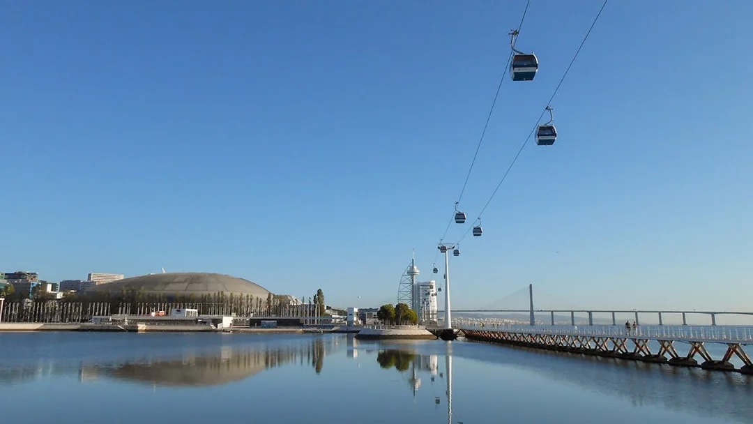 Telecabine cable car over Tagus River with Lisbon skyline in the background.