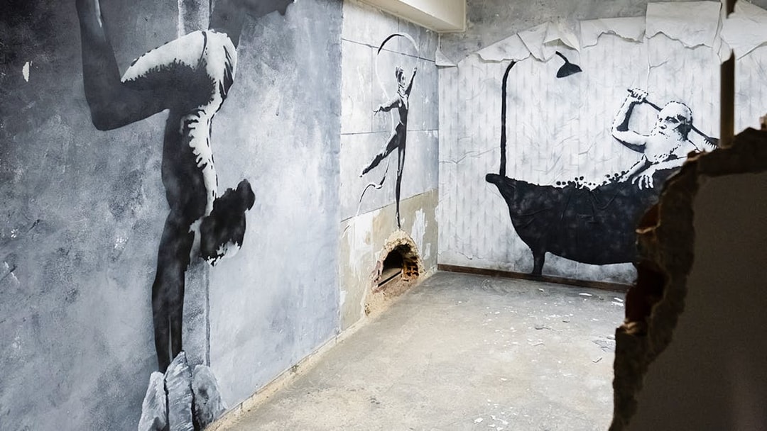 Street art murals at The Banksy Museum in Lisbon featuring acrobat and bather.