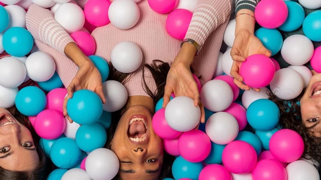 Visitors enjoying a colorful ball pit at Big Fun Museum, Barcelona.