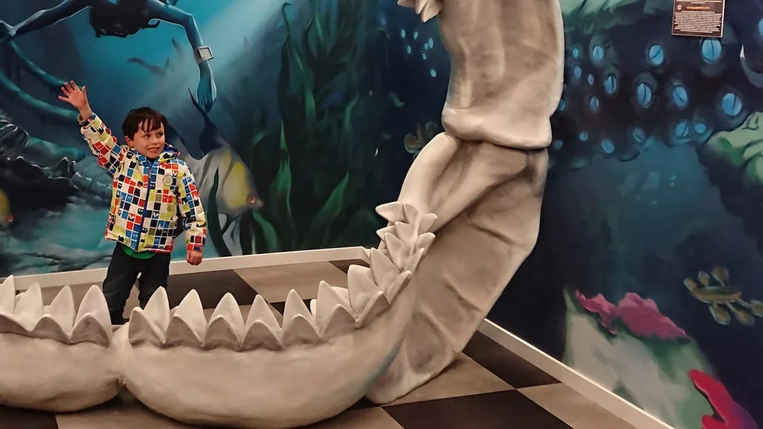 Child playing inside giant jaws exhibit at Big Fun Museum, Barcelona.