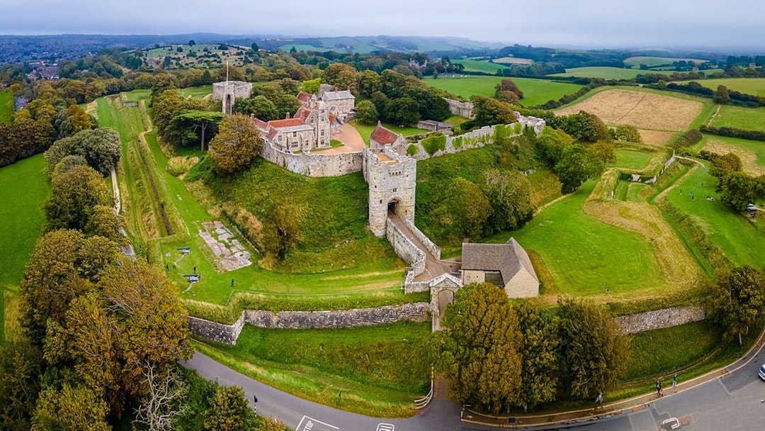 Aerial view of Carisbrooke Castle, Isle of Wight, surrounded by lush greenery and historic walls.