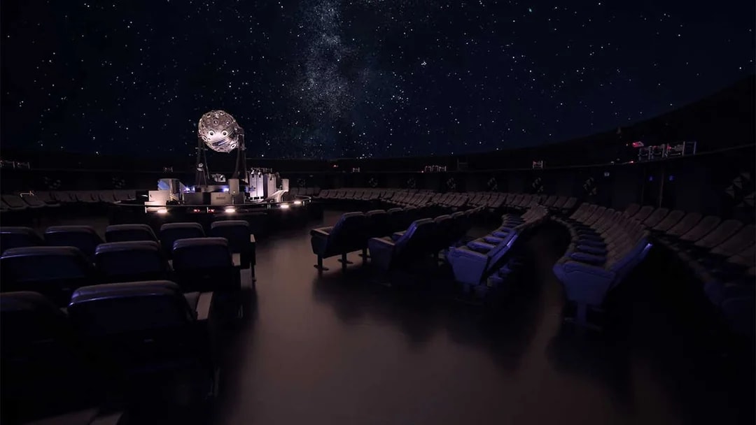 Navy Planetarium interior with starry sky projection and seating arrangement.