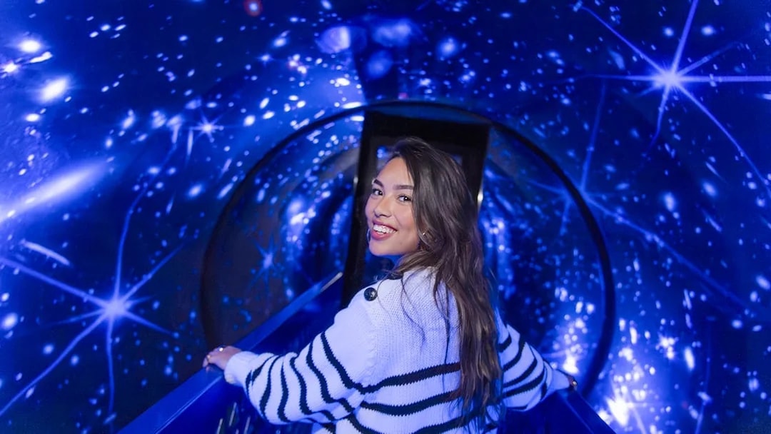 Person walking through a starry tunnel experience called The TUBE.