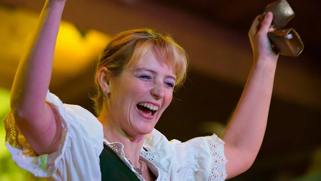 Performer at Tyrolean Evening Folk Show with Gundolf Family, holding cowbells.