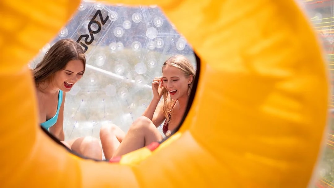 Two people enjoying a Zorb giant inflatable ball ride.
