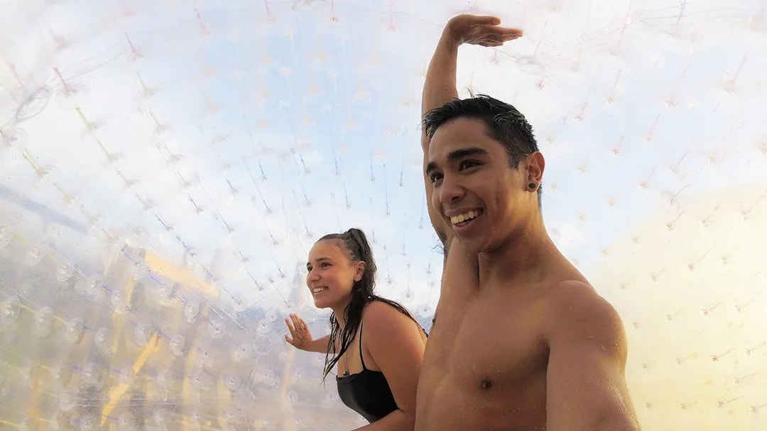 Two people inside a transparent Zorb ball enjoying the ride.