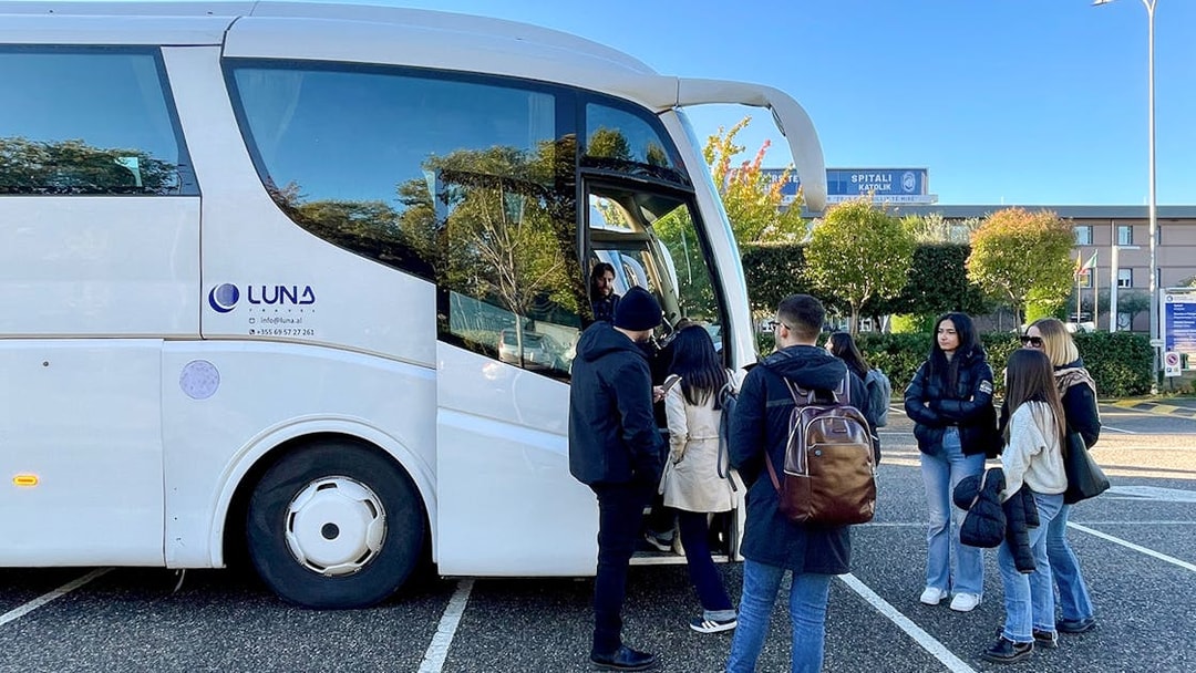 Passengers boarding a bus at Tirana Airport for transfer to Tirana Central.