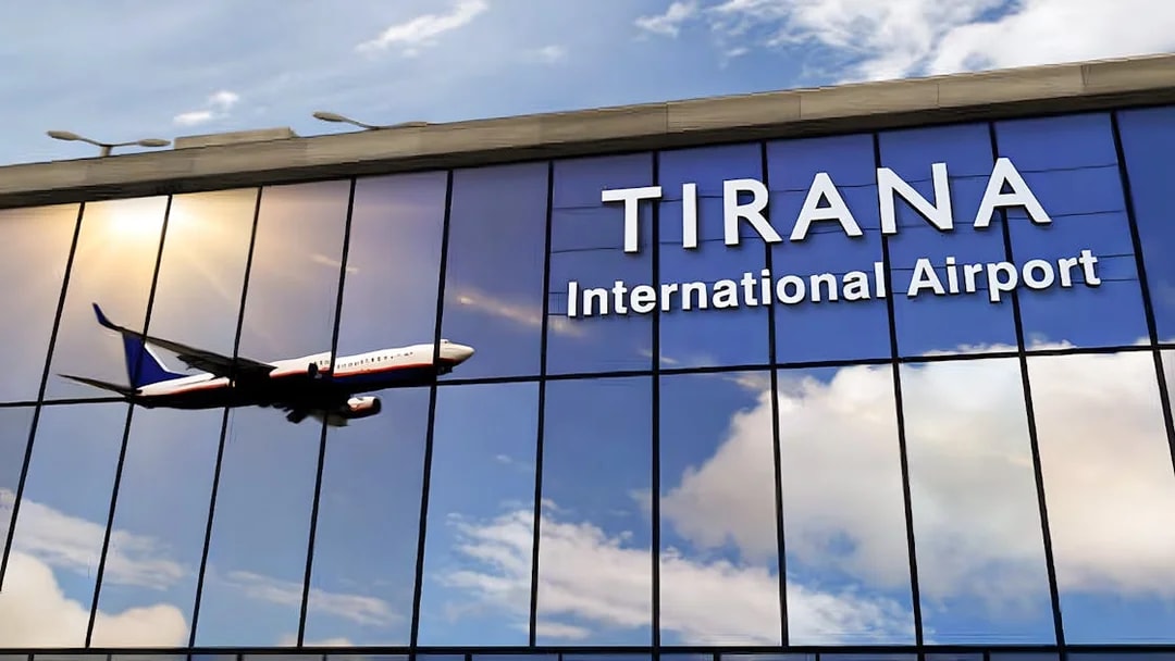 Tirana International Airport facade with airplane reflection.
