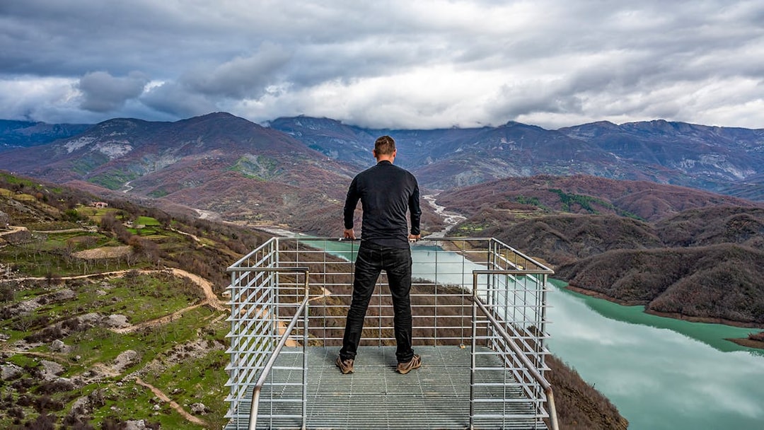 Guest overlooking Bovilla Lake from a viewing platform, surrounded by mountains.