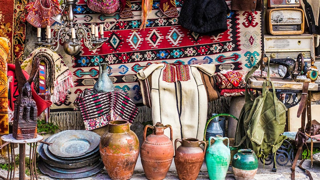 Kruja flea market with traditional Albanian crafts, pottery, and textiles displayed.