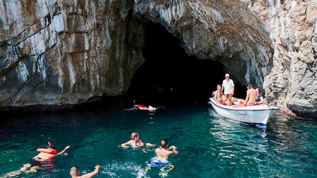 Swimmers and a boat near the entrance of the Blue Cave, Kotor.